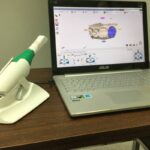 laptop on a table with dental equipment